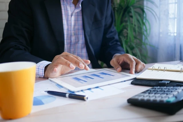 Business owner reviewing financial charts and a calculator at a desk